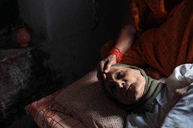 Uttar Pradesh Hindistan 'da, Kashi Labh Mukti Bhawan' da yatakta uyuyan kadın hastalığı 