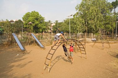 MCGM, Bombay, Mumbai, Maharashtra, Hindistan tarafından bakılan bir bahçede oynayan çocuklar. 