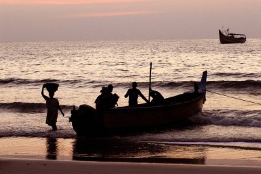 Balıkçı teknesi ve balıkçılarla dolu renkli günbatımı, Malpe Sahili, Arap Denizi, Udupi, Karnataka, Hindistan 