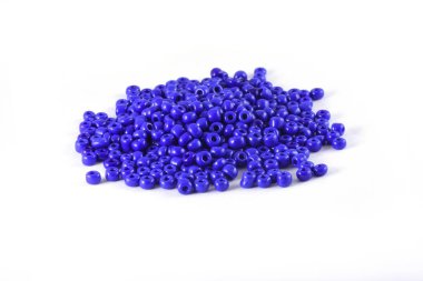 Boncuklar beyaz arka plana yayılmış. Arkaplan ya da boncuk dokusu. Yaklaş makro, moda kıyafetlerini bitirmek için kullanılır. Boncuklu kolye ya da boncuklu boncuk yap moda kadını, Boncuk Tığ. Günlük Boncuk.