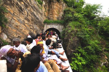 Trenin çatısında seyahat ederken risk alan insanlar tünelden geçiyorlar, Rajasthan, Hindistan 