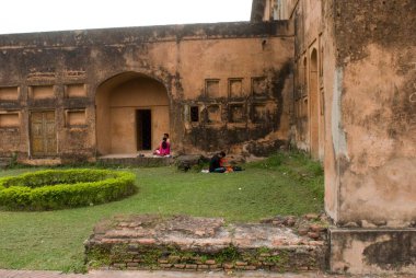 Couple sitting in Lalbagh fort  built by prince Muhammad Azam; Son of Mughal Emperor Aurangzeb in 1678 AD ; Dhaka ; Bangladesh clipart