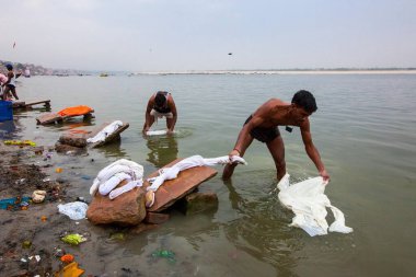 Ganga Nehri Ganj Nehri, Varanasi, Banaras, Benaras, Kashi, Uttar Pradesh, Hindistan 'da çamaşır yıkayan adam.
