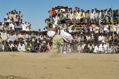 İnsanlar Bakh Mal Akhada 'nın Shivratri panayırı, Kutch, Gujarat, Hindistan' da güreşmesini izliyor. 