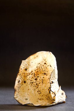 Hint usulü kızarmış papad, siyah arka planda koni şeklinde. 