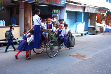 Çocuklarla dolu bir triportör; Haridwar, Uttar Pradesh, Hindistan 