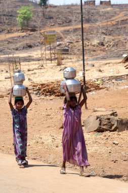 Young girls carrying pots of water from well at Mal village, Thane, Maharashtra, India, Asia clipart