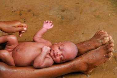 Ho tribes mother bathing baby. Chakradharpur. Jharkhand. India    clipart