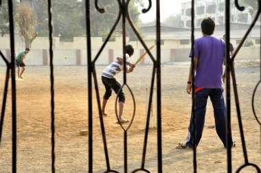 Çocuklar Mumbai Maharashtra Hindistan 'da kriket oynuyor.   