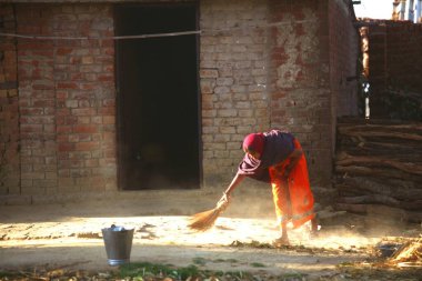 Jharkhand, Hindistan 'daki evinin dışını temizleyen kadın. 