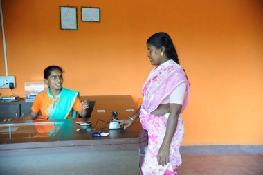 IFMR Vakfı, Thanjavur, Tamil Nadu, Hindistan 'dan Ngo kshtriya gramin finans hizmetleri tarafından gönüllü olarak bankada baş parmak presi cihazı kullanan kırsal bir kadın.   