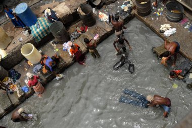 Çamaşırcı adamlar Bombay 'daki Dharavi' nin kirli sularında çamaşır yıkıyorlar şimdi Mumbai, Maharashtra, Hindistan