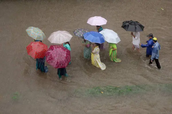 Stock image showing People are walking with color umbrella in flooded water, Monsoon, world record rain in Kalyan, Bombay now Mumbai, Maharashtra, India.