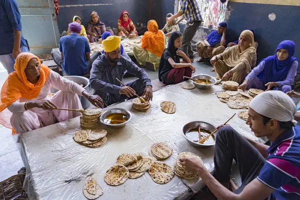 Chapatti, Altın Tapınak, Amritsar, Punjab, Hindistan ve Asya 'ya ghee uygulayan insanlar 