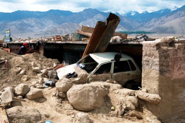 Leh, Ladakh, Jammu ve Kashmir, Hindistan 'da meydana gelen sel felaketinden dolayı Choglamsar' da çamura saplanmış bir araba. 