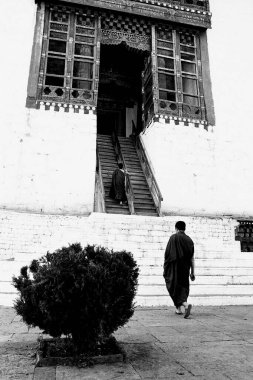 Monks climbing stairs in Buddhist Monastery Thimphu Bhutan 1989 clipart