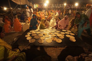 Sih kadın düşkünleri, Sachkhand Saheb Gurudwara 'da toplum mutfağında rotis pişiriyorlar. Guru-Granth Sahib' in 30. yılı, Maharashtra, Hindistan 30-Ekim-2008 