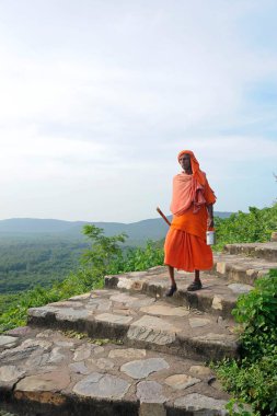 Holy man stepping down ; Buddhist site ; Rajgir ; Bihar ; India clipart