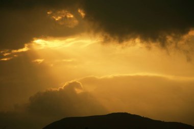 Gün batımı, bulutların arasından gelen ışık ışınları, Hindistan