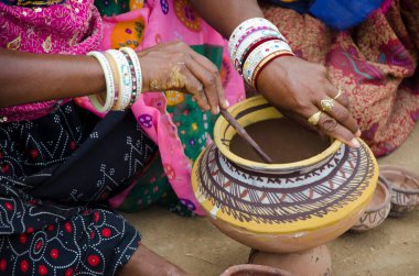 Jaisalmer Rajasthan Hindistan Asya 'da kil çömlek üzerinde çizim yapan kadın  