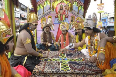 Janmashtami festival or Lord Krishna birthday celebration carnival procession with various scene from epic Mahabharat depicting game like chess played by models dressed up as Kauravas and Pandavas, Jabalpur, Madhya Pradesh, India   clipart