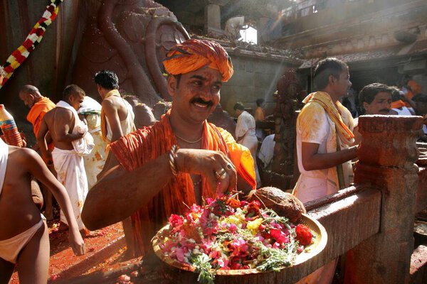 Devotee carrying plate full of flowers to sprinkle on 18 meter high statue of Bhagwan Gomateshwara Bahubali during Mahamasthakabhisheka Jain festival held once every twelve years, Shravanabelagola, Hassan district, Karnataka state, India  