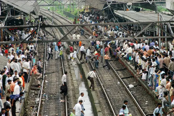 stock image Commuters dangerously cross railway tracks to catch local train risking their lives at Ghatkopar Railway Station in Bombay Mumbai, Maharashtra, India 