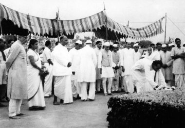 People paying homage at Rajghat, Delhi, where Mahatma Gandhis funeral took place, 1948, Abdul Kalam Maulana Azad, Sucheta Kripalani, Shem Prasad Mukherjee, Jawaharlal Nehru, Acharya Kripalani, placing a flower garland, India    clipart
