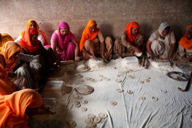 Langar 'da ya da Harmandir Sahib' de kamu mutfağında ya da Amritsar, Punjab, Hindistan 'da Altın Tapınak' ta hizmet veren kadınlar 