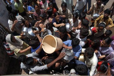 İnsanlar Parel, Mumbai Bombay, Maharashtra, Hindistan 'da su için bir tankere doğru koşuyorlar.  