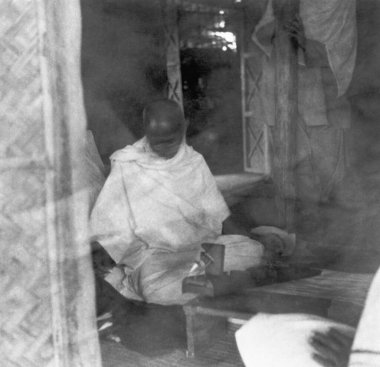 Mahatma Gandhi spinning in his hut at Sevagram Ashram , 1939  clipart