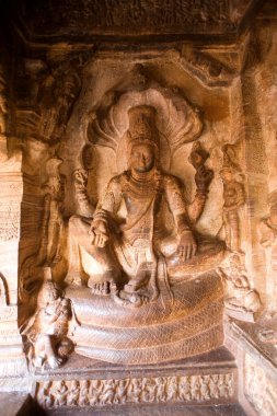 Vishnu sarmalanmış yılanın üzerinde oturuyor, Badami, Bagalkot, Karnataka, Hindistan 