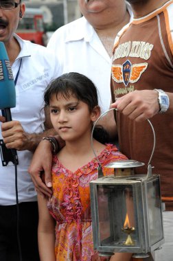 Young girl protesting with lamp outside the Taj Mahal hotel, after terrorist attack by Deccan Mujahedeen on 26th November 2008 in Bombay Mumbai, Maharashtra, India    clipart