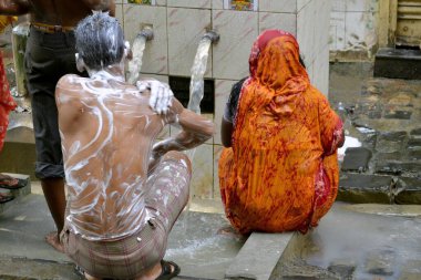 Kolkata Batı Bengal Hindistan Asya yolunda banyo yapan kadın ve erkek.