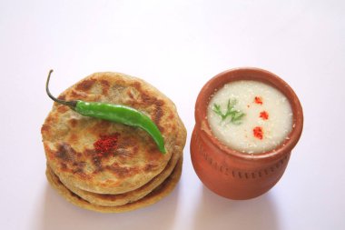 Bhakri jowar bread with green chilli and buttermilk in earthen pot on white background clipart