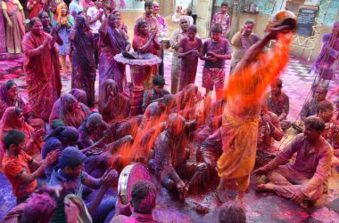 Priest pouring wet colour on devotees ghanshyam temple Jodhpur Rajasthan India Asia  clipart