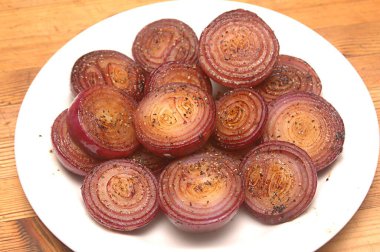 Food , sauted red onions spiced with crushed black pepper on a white plate clipart