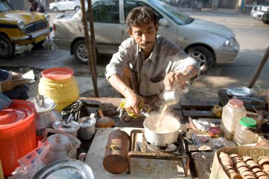 Çaydanlıktan çaydanlığa buhar çayı döken çay satıcısı; Kalküta şimdi Kolkata; Batı Bengal; Hindistan