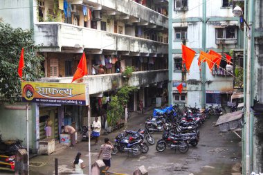 Safhali toplumda park edilmiş bayrak ve motosikletler, Sakharam Balaji Pawar Marg, Curry Road, Bombay Mumbai, Maharashtra, Hindistan 26-Ağustos-2009 