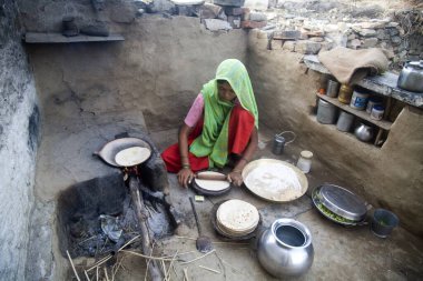 Hintli kırsal kadın chapaati ekmeği yapıyor; ev işi; Delwada köyü; Udaipur; Rajasthan; Hindistan