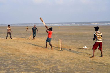 Mandarmoni Kolkata Batı Bengal Hindistan Asya sahilinde kriket oynayan çocuklar.