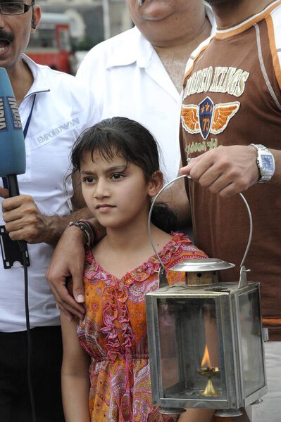 Девушка протестует с лампой возле отеля Тадж-Махал, после террористического нападения Декана Моджахедина 26 ноября 2008 года в Бомбее, Махараштра, Индия   