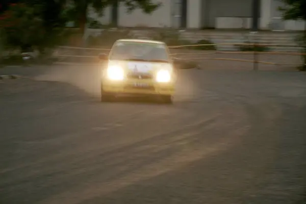 stock image Speeding yellow car at bend with dust flying and headlights on in race held at Balewadi Sports Complex, Pune