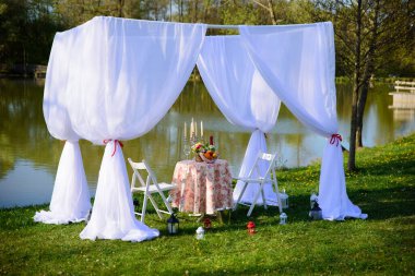 Göldeki bir parkta, mumlar ve çelenklerle süslenmiş güzel bir çadırda buluşma ya da evlenme teklifi için romantik bir yer. Meyveli bir masa ve bir şişe şarap..