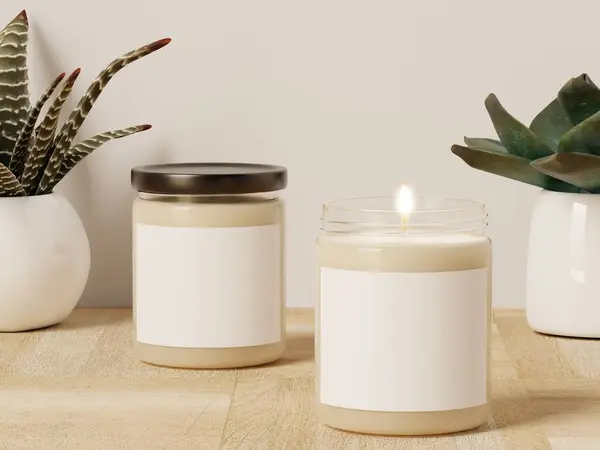 Two scented glass soy white candles and succulent plants on a wooden surface with a white wall decor. Blank label for logo, text or design.