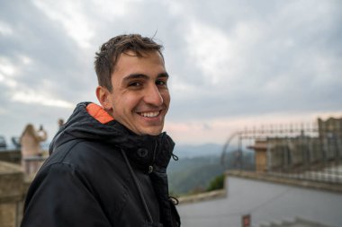 Brunet 'li genç adam, kışın kameraya yaramaz bir suratla bakıyor..