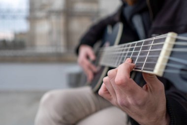 Sokakta tek başına gitar çalmayı öğrenen bir adamın ellerine yakın çekim..