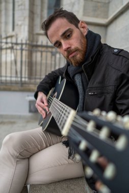 Kızıl sakallı adamın gitar çalmayı öğrenmesi. Dikey.