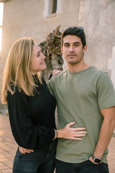 Sarışın kadın kameraya ciddi ciddi bakarken erkek arkadaşının gülümsemesine bakıyor. Çift kavramı.