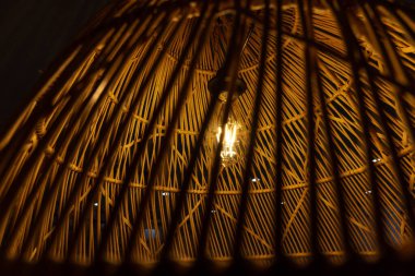 Ilık ışıklı ampul, enerji yoksunluğu olan bir evi aydınlatıyor. Enerji krizi kavramı.